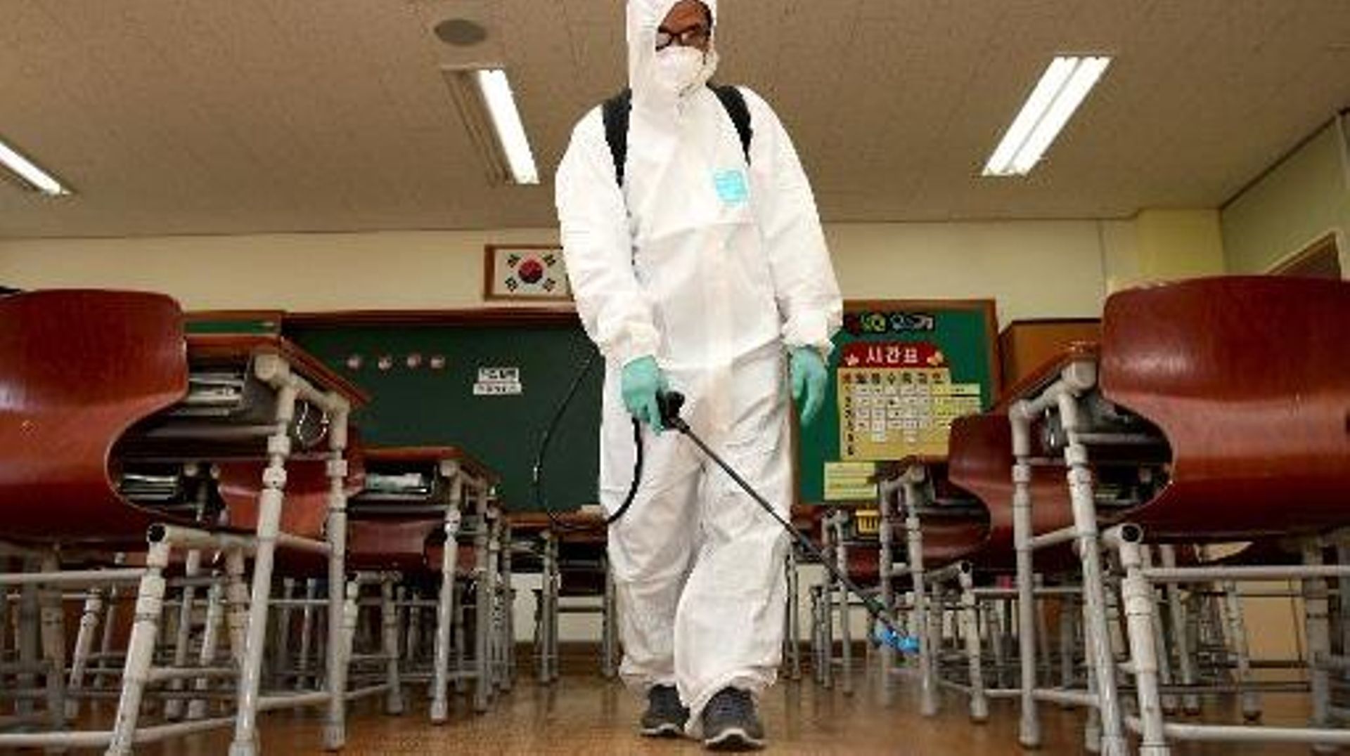 Un homme désinfecte une salle de classe dans une école primaire de Séoul, le 14 juin 2015