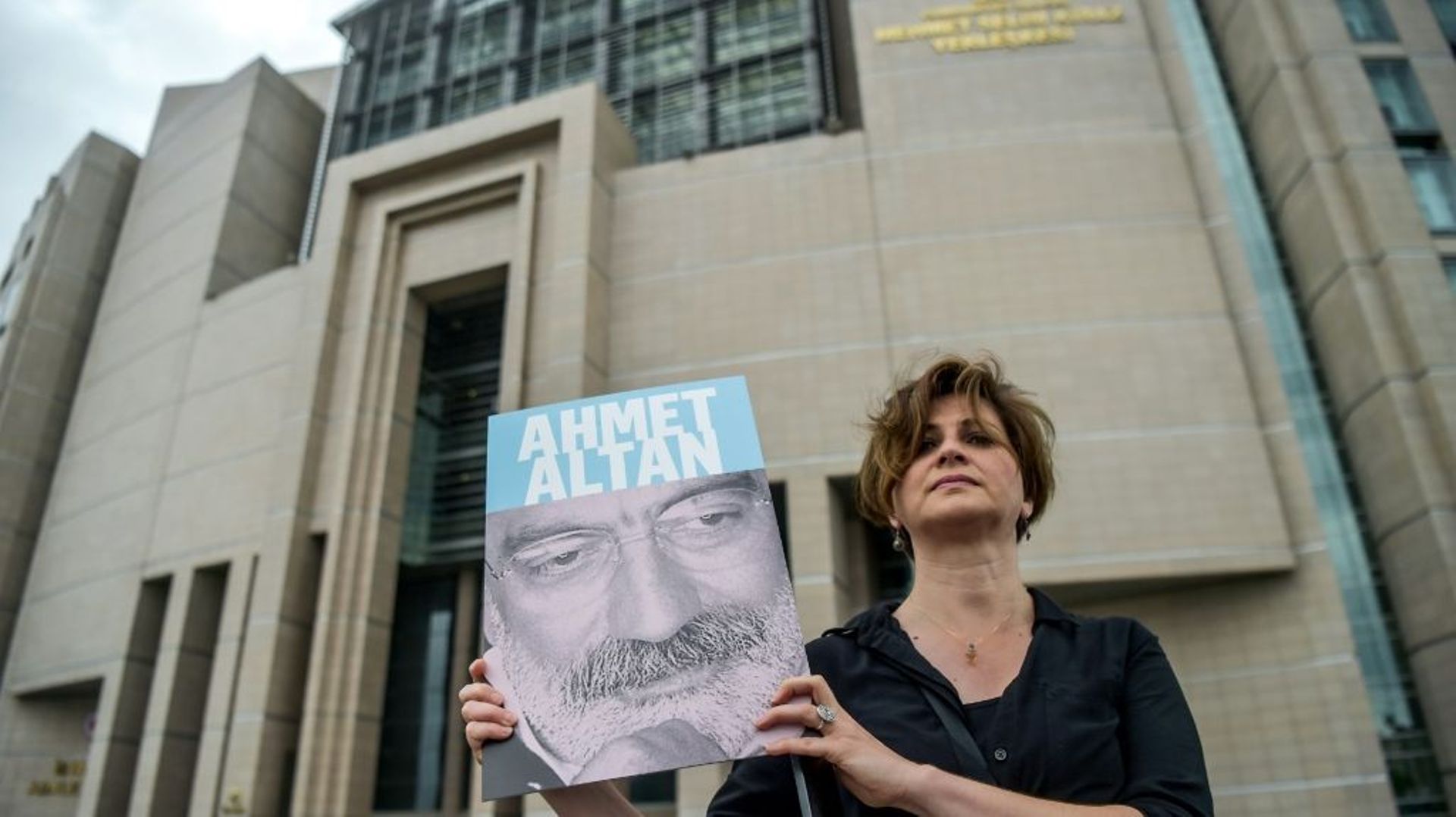 Une journaliste pose avec le portrait d'Ahmet Altan devant le tribunal d'Istanbul, le 19 juin 2017