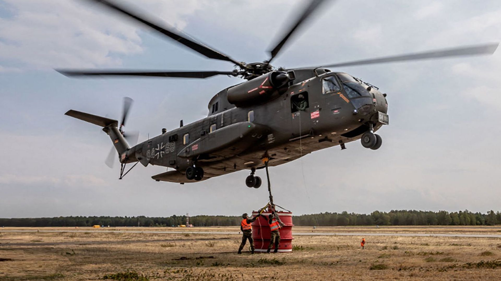 Cette photo prise le 18 juin 2022 et reçue le 19 juin 2022 par l’armée de l’air des forces armées allemandes Bundeswehr montre des soldats fixant un conteneur sur un hélicoptère CH-53 pour puiser de l’eau dans un lac voisin afin d’éteindre un feu de forêt