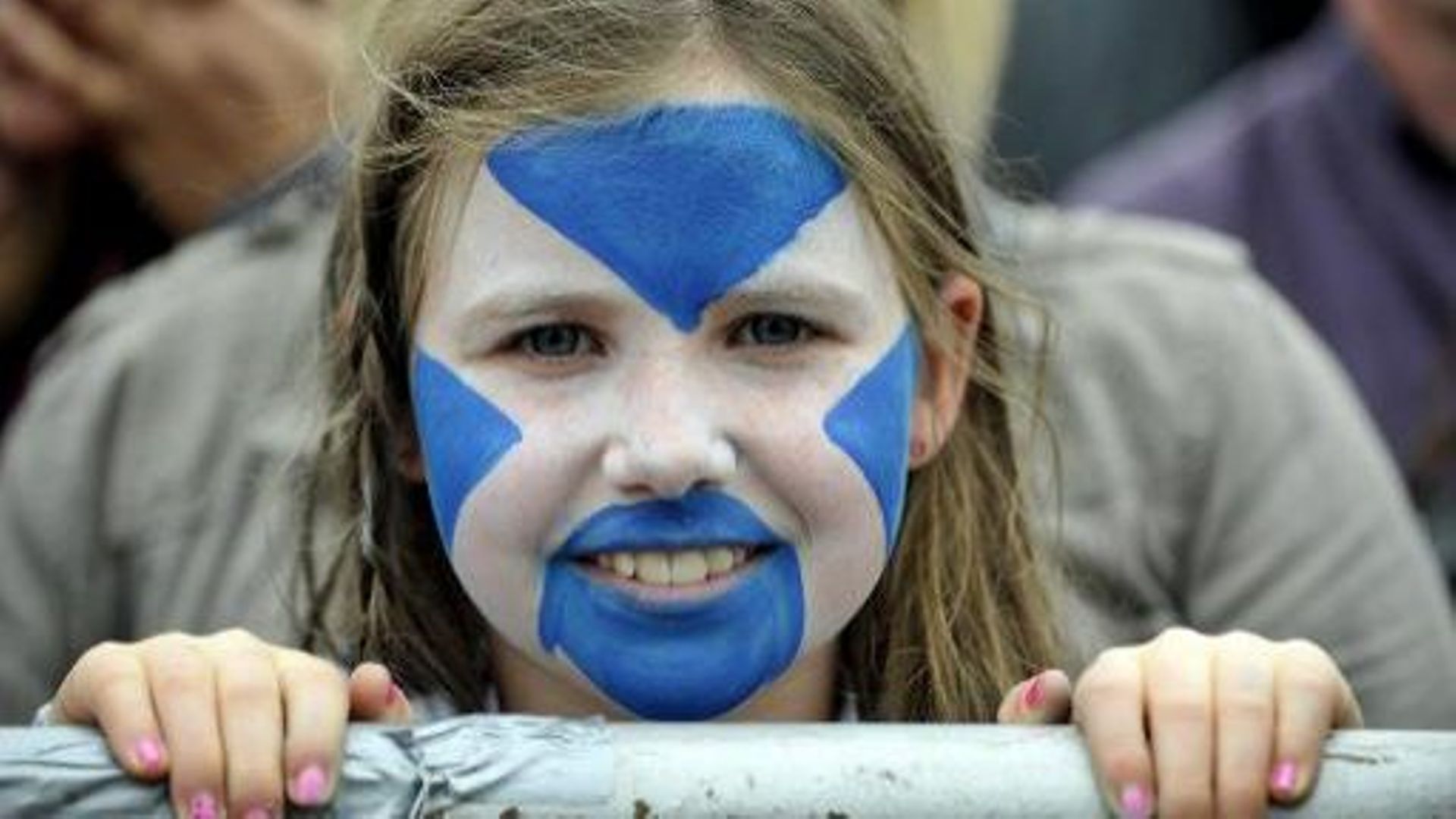 Une fillette manifestait avec le visage peint aux couleurs du drapeau écossais