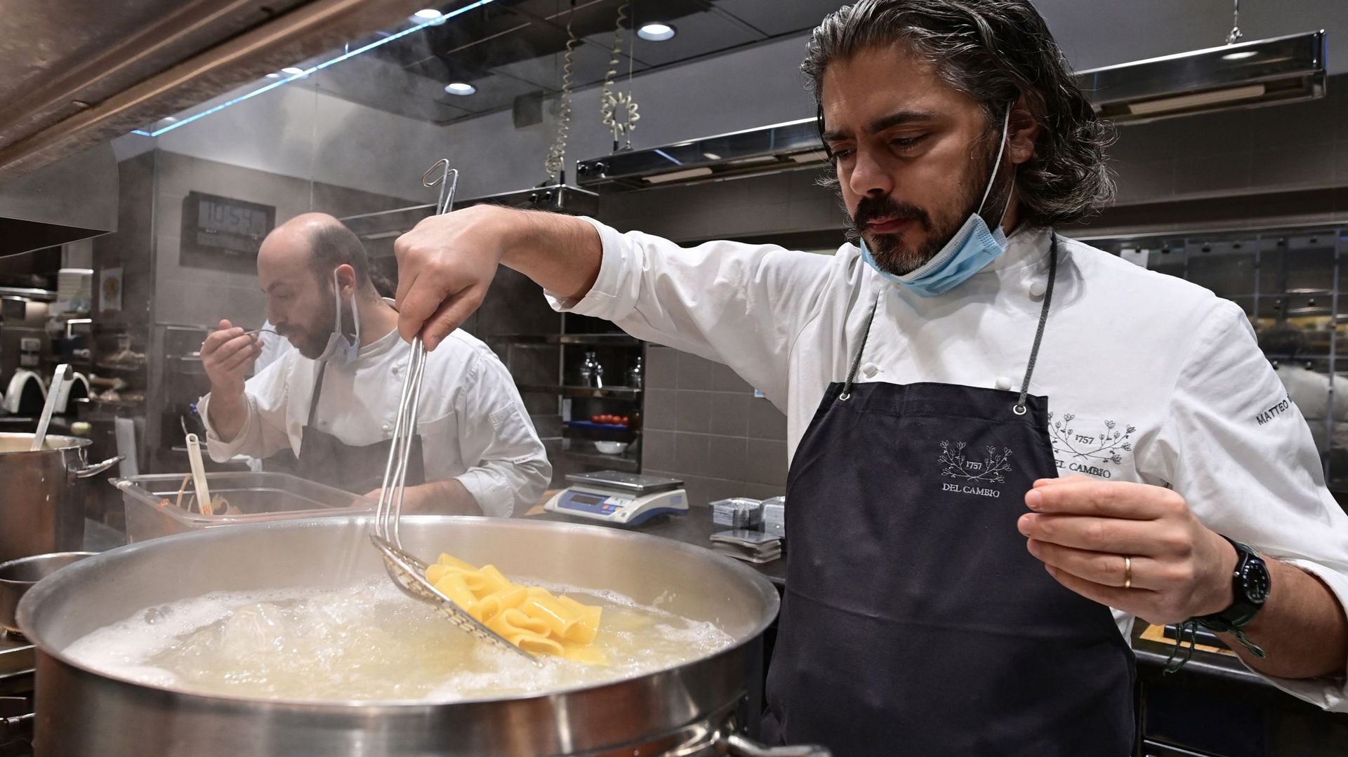 Le chef Matteo Baronetto (droite) et son assistant Vittorio di Palma, du restaurant étoilé Michelin Del Cambio, préparent des pâtes avec une sauce à la viande le 17 novembre 2020 à Turin