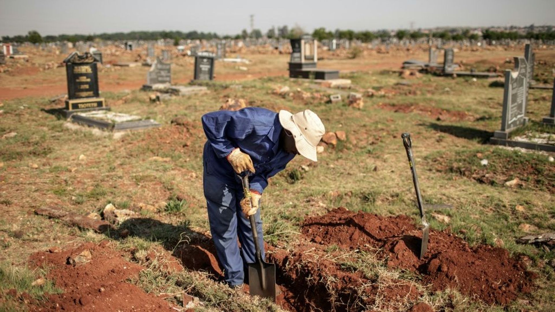 Un fossoyeur creuse une tombe au cimetière d'Avalon de Soweto, le 15 novembre 2018 à Johannesburg.
