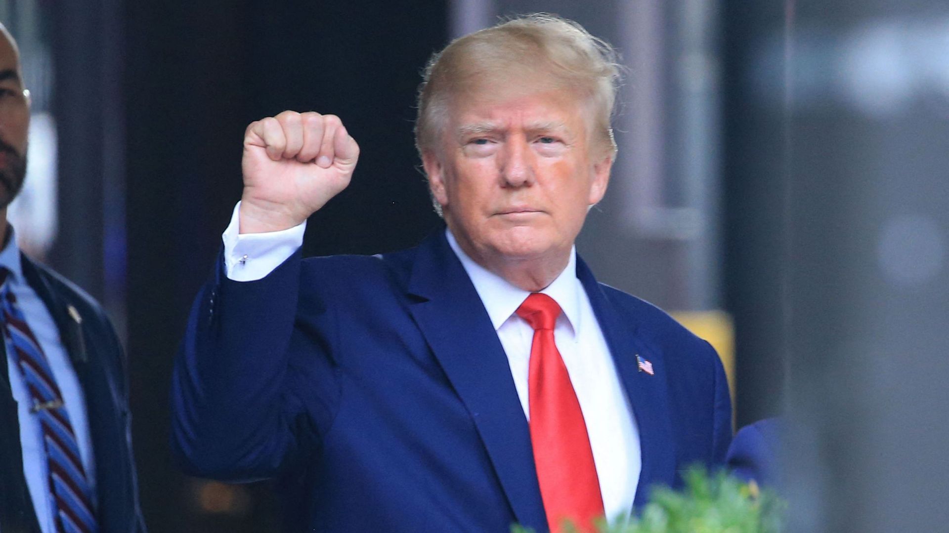 L'ancien président américain Donald Trump lève le poing en se dirigeant vers un véhicule à l'extérieur de la Trump Tower à New York, le 10 août 2022. 