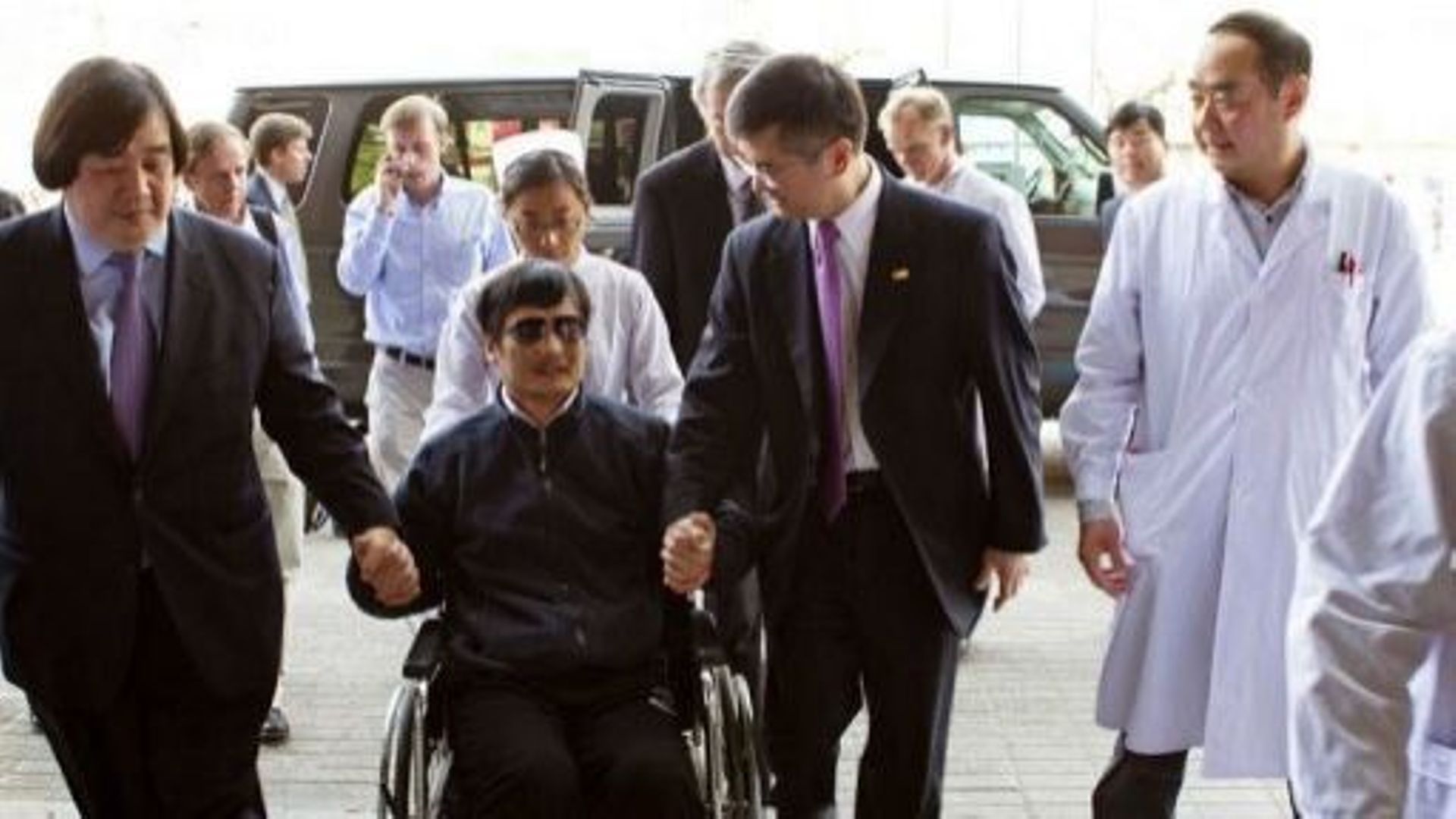 Le militant des droits civiques, Chang Guangcheng (C), accompagné de l'ambassadeur américain à Pékin, Gary Locke (D), le 2 mai 2012 à Pékin
