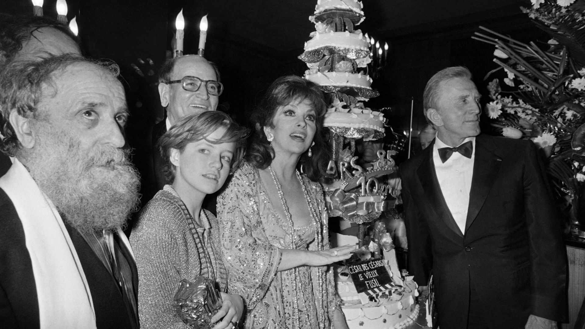 Le sculpteur français César, l’actrice française Laure Marsac, l’actrice italienne Gina Lollobrigida et l’acteur américain Kirk Douglas posent à côté d’un gâteau à l’occasion de la 10e nuit des César, le 2 février 1980, à Paris.