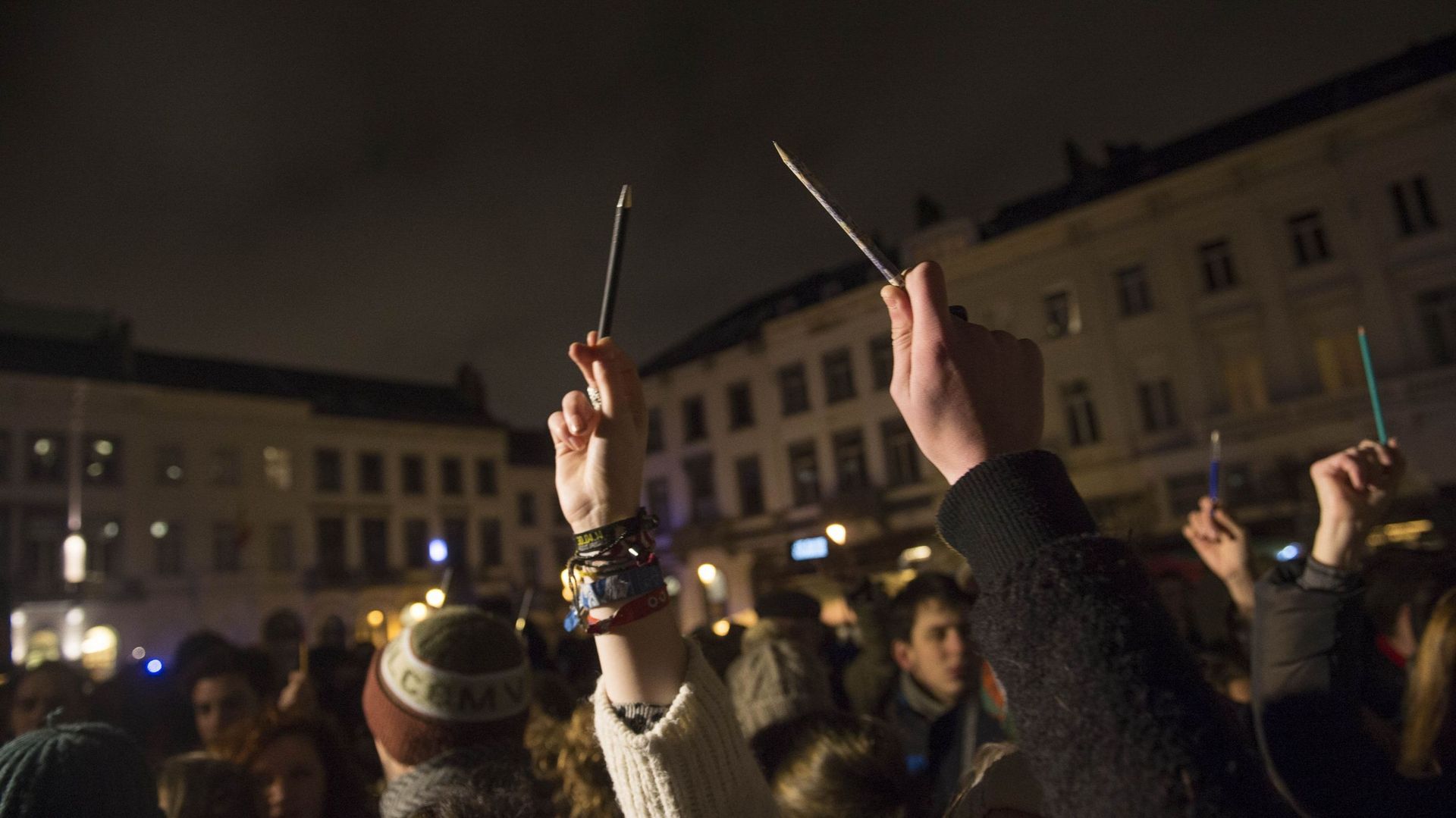 Des manifestants brandissent des crayons en hommage aux victimes de l'attaque, à Bruxelles.