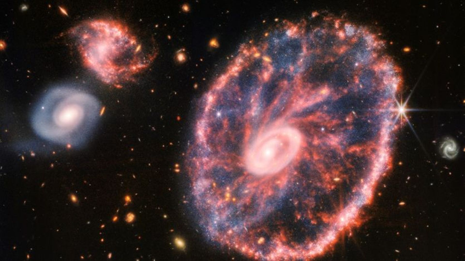 Image composite publiée le 2 août 2022 par la Nasa de la galaxie de la Roue de chariot et deux autres galaxies plus petites observées par le télescope James Webb