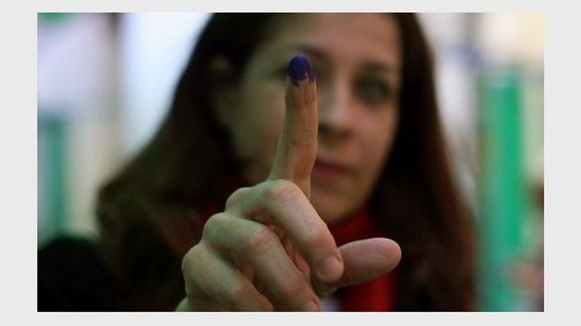 Une femme montre son doigt marqué à l'encre après avoir voté pour élire la chambre haute (Choura) du parlement, le 29 janvier 2012 au Caire.
