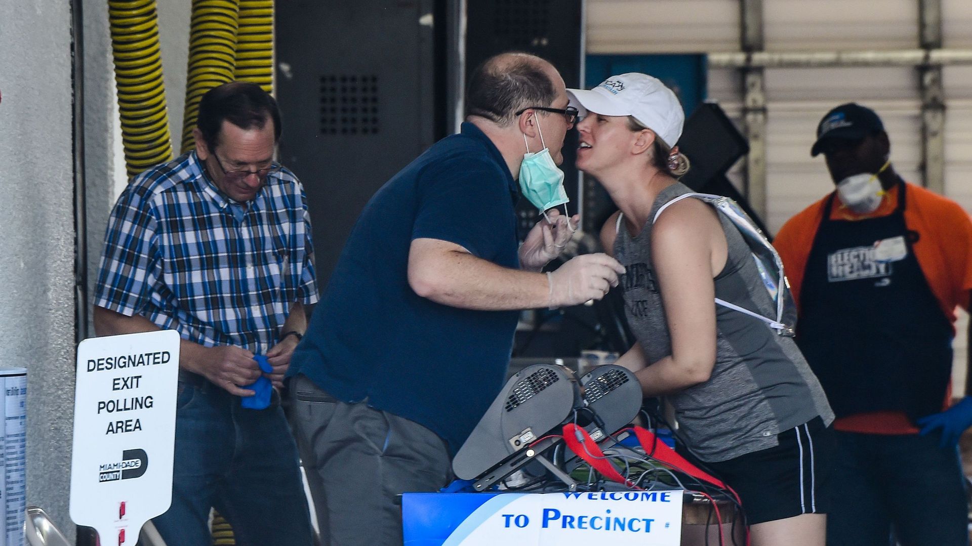 Une femme embrasse le travailleur électoral avant de voter lors des élections primaires en Floride à Miami, le 17 mars 2020. Des millions d’Américains inquiets se sont rendus aux bureaux de vote le 17 mars 2020 dans trois Etats, mais pas dans l’Ohio, alor