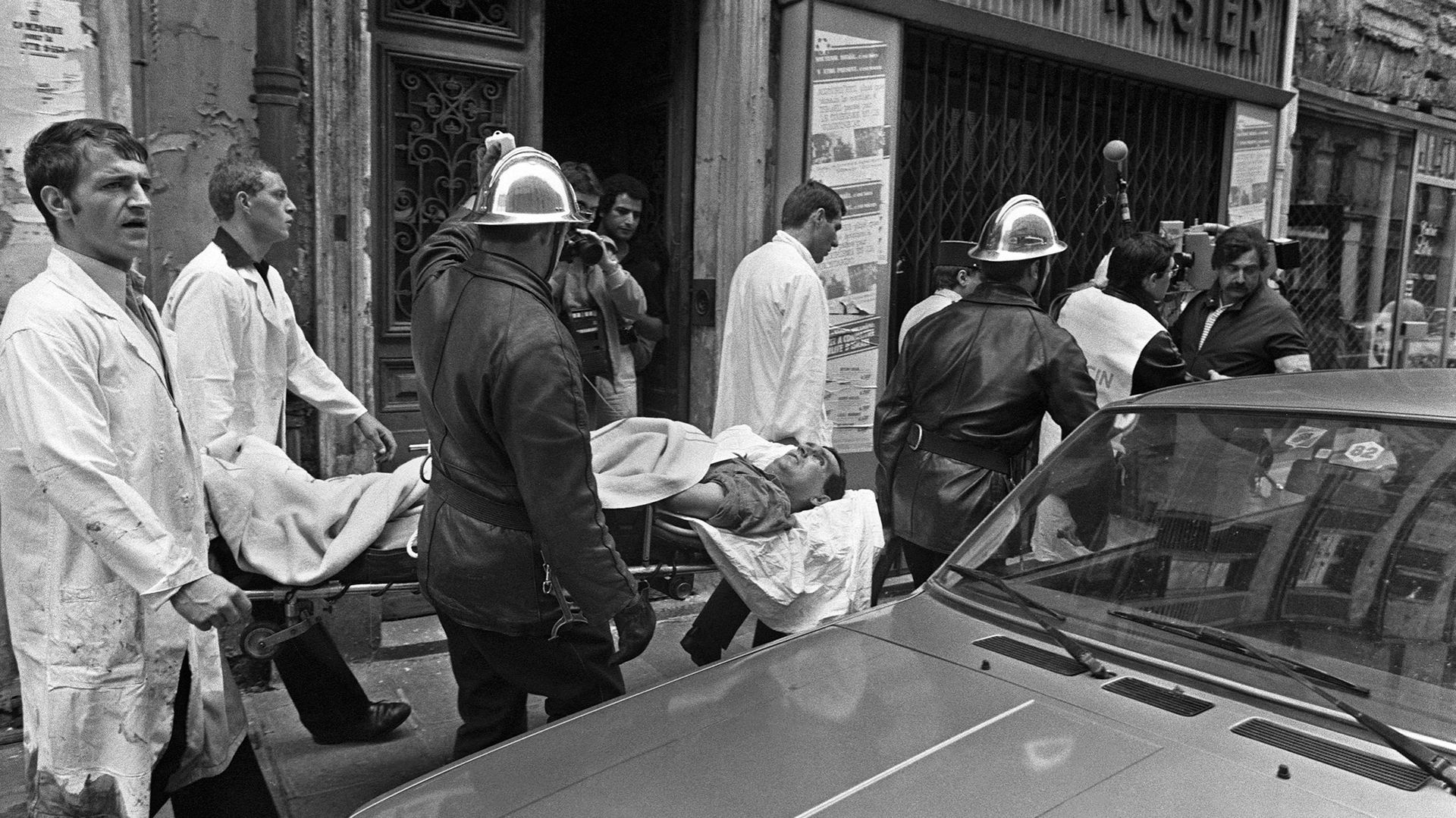 Des pompiers évacuent un blessé le 9 août 1982 au coeur du vieux quartier juif à Paris