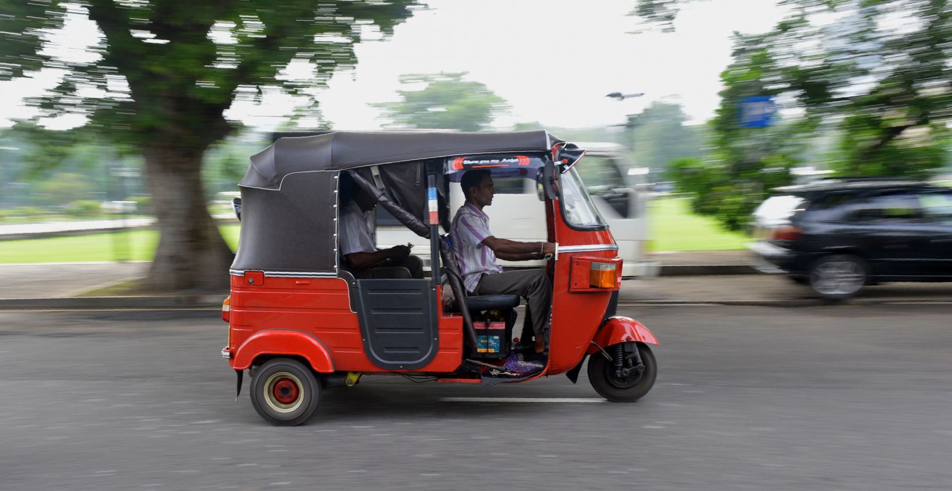 Un homme srilankais conduit un taxi à trois roues, appelé tuk-tuk, dans la ville de Colombo